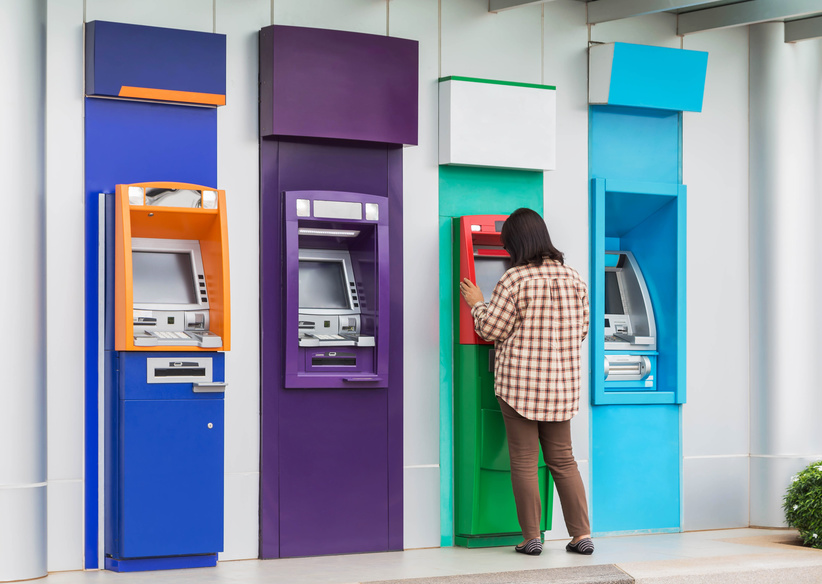 asian woman standing withdrawing money from banking machine or ATM(Automatic Teller Machine)